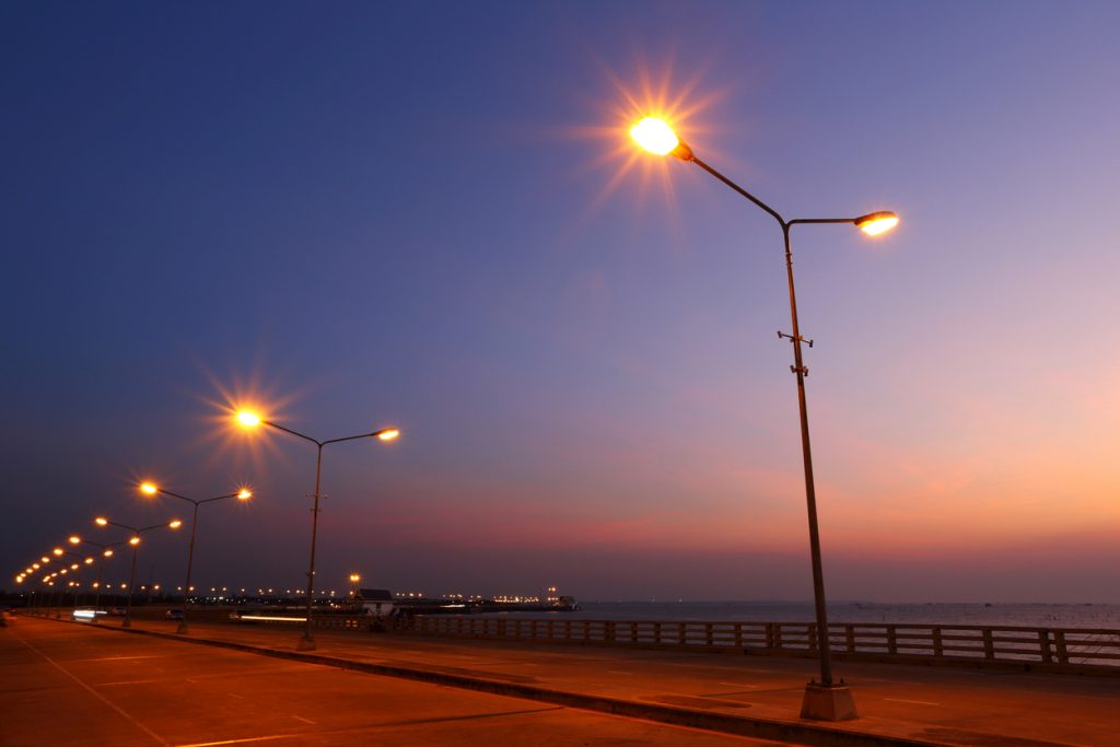 Built By She - Storyteller - Sky view and bridge with street light illuminated in the sunset