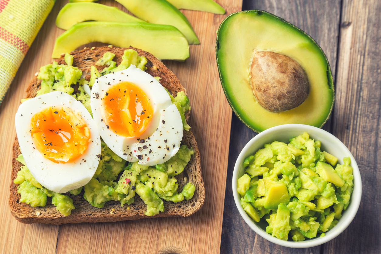 Built By She - Toast with avocado and egg on rustic wooden background